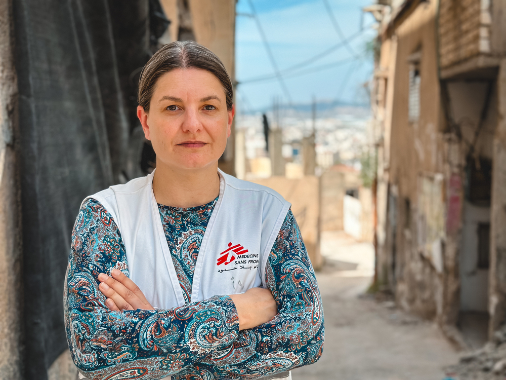 Photo of woman with arms folded wearing a white vest