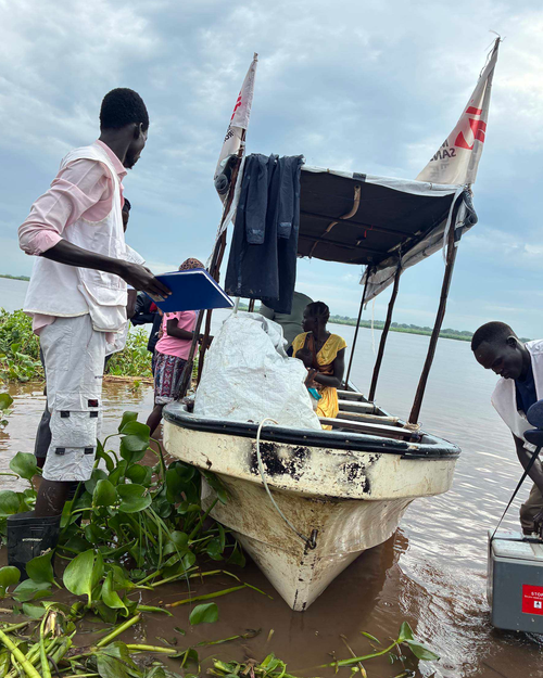 Image of an MSF team assisting a patient on the Sobat river