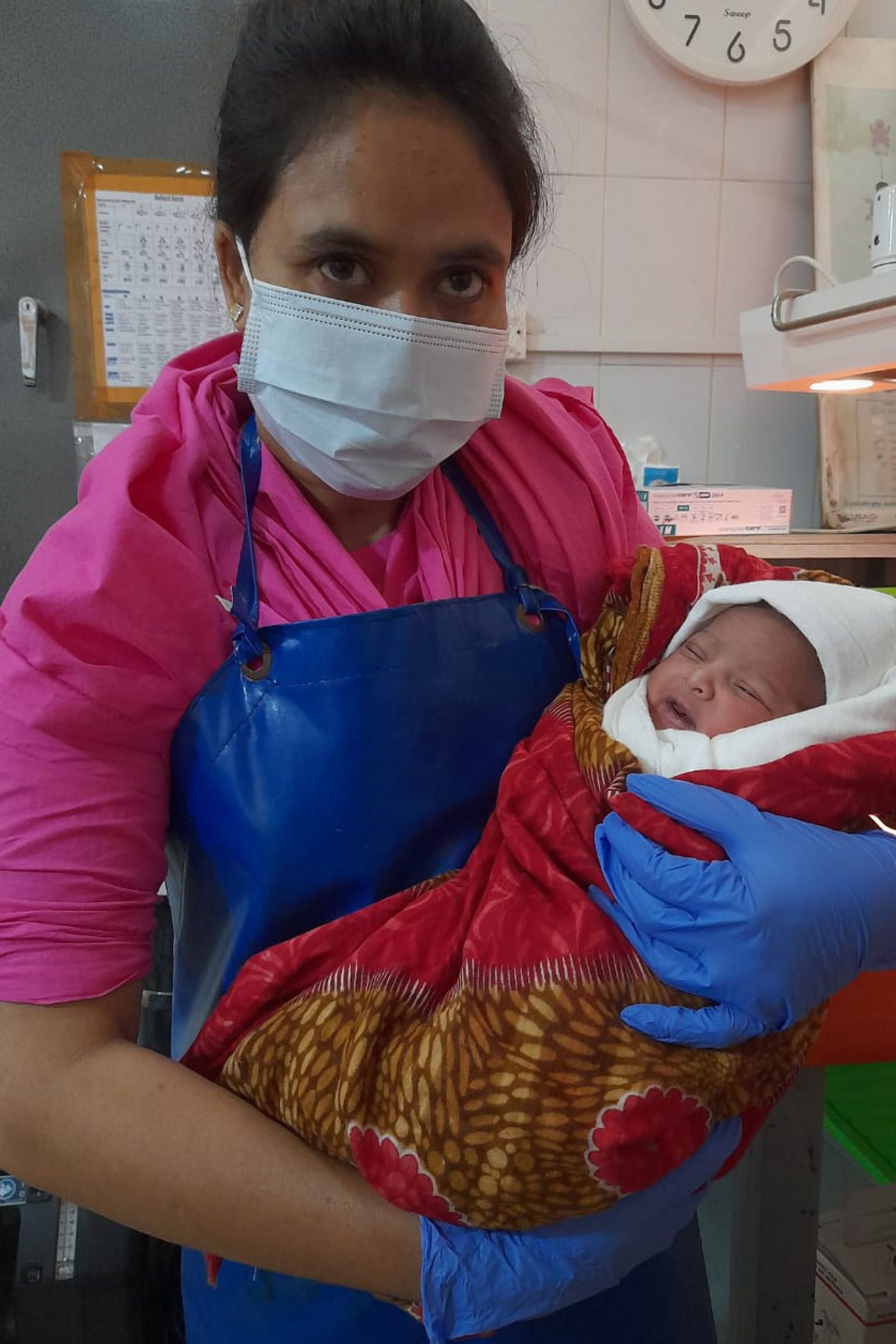 Mohammad, held by one of the midwives who helped deliver him