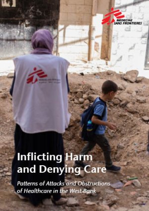 Photo of an MSF team member and a boy on a destroyed street